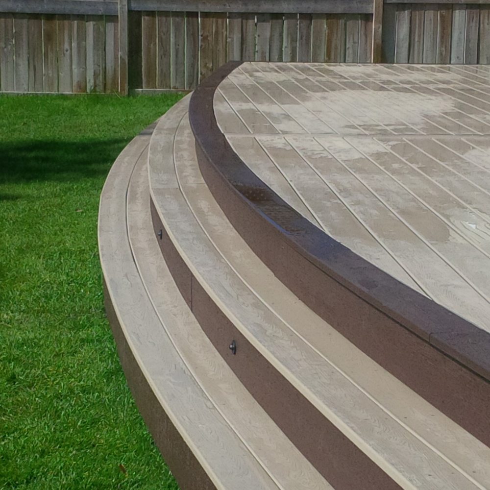 custom deck steps leading down to green grass of backyard