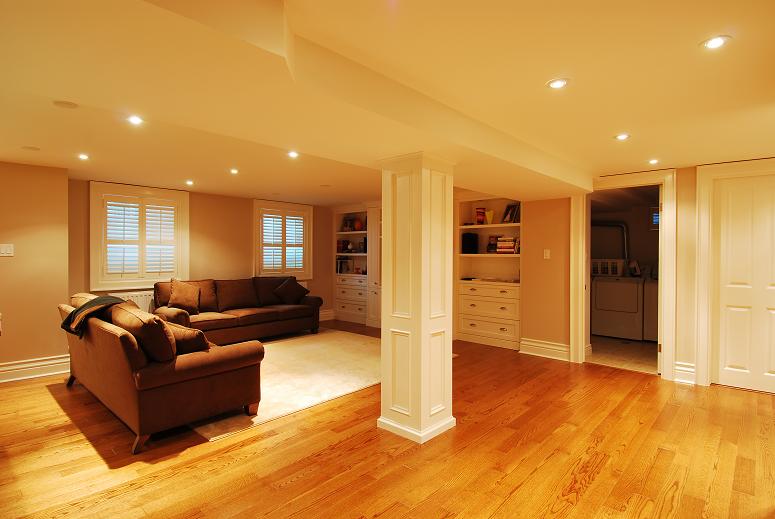 newly renovated basement in ottawa with hardwood floors shelving and couches