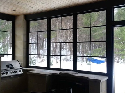 enclosed porch with barbecue looking out into wintery forest