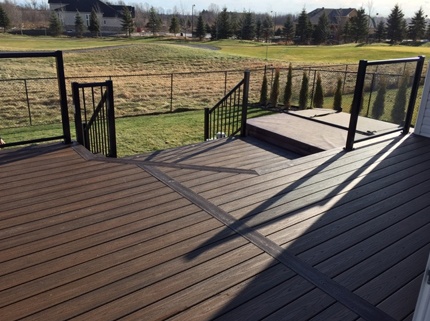 clean custom deck with black railings overlooking backyard and field