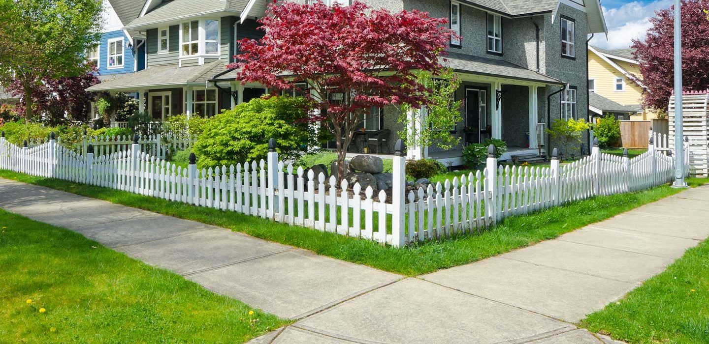 beautiful corner home with white picket fence surrounding front yard