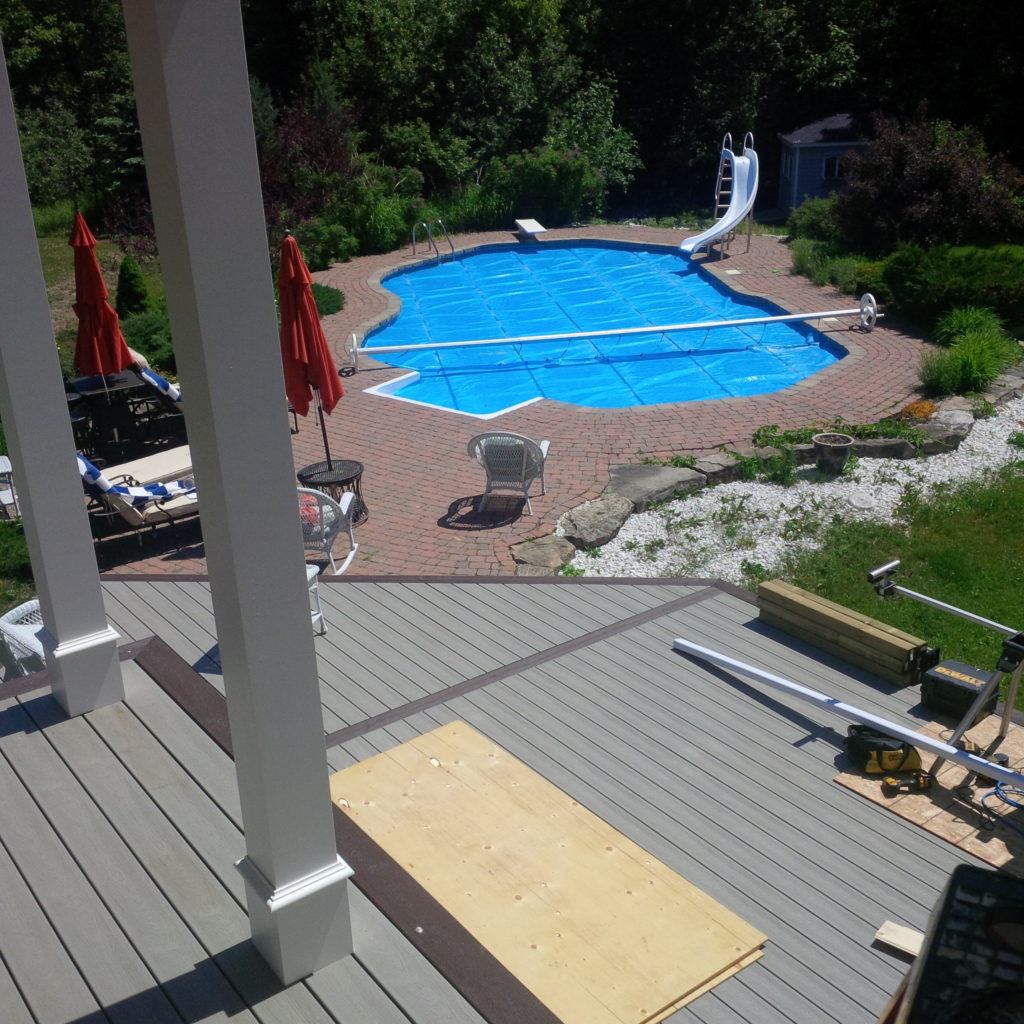 under construction custom deck overlooking ottawa backyard with pool and waterslide