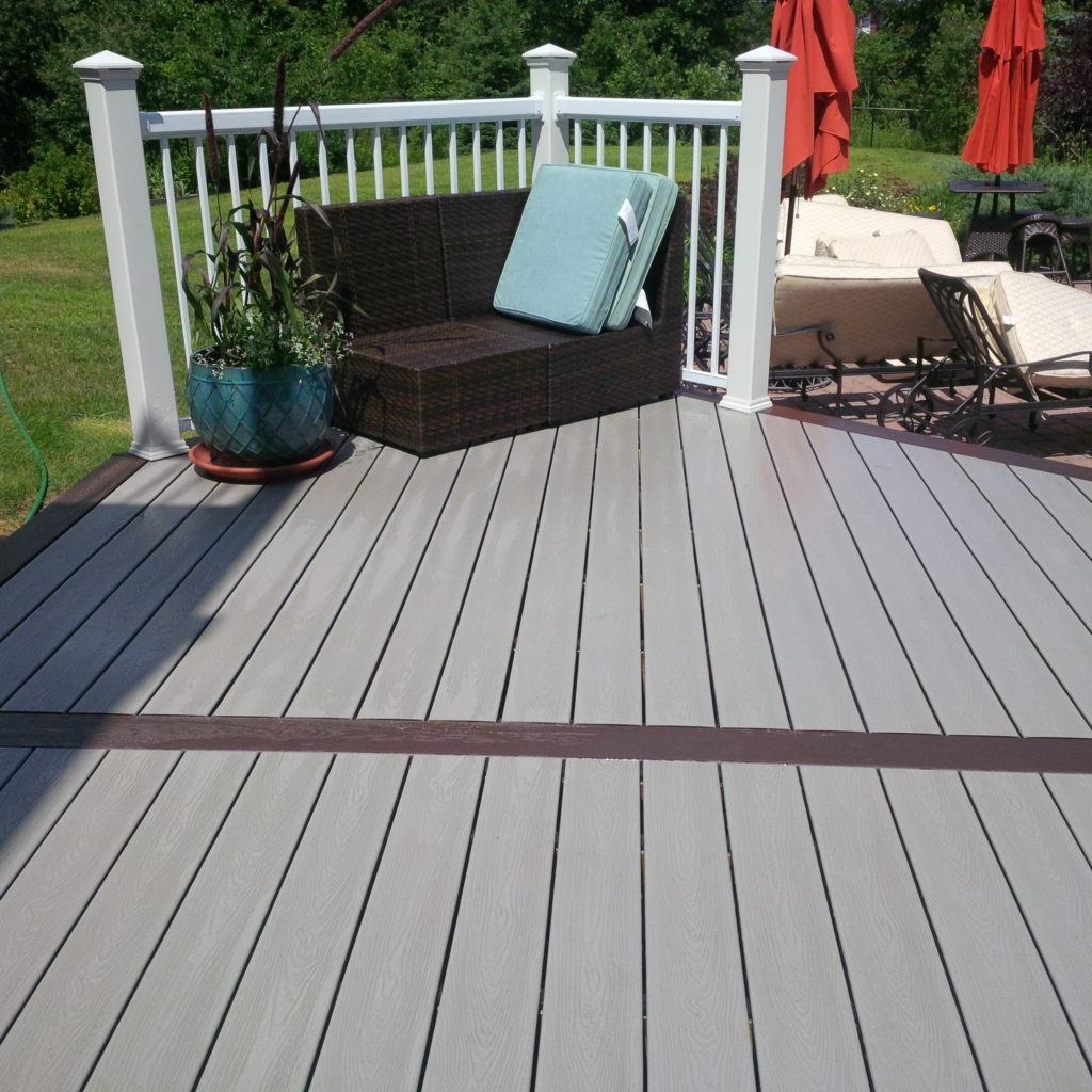 finished custom deck with railings and small plant and chair with cushions
