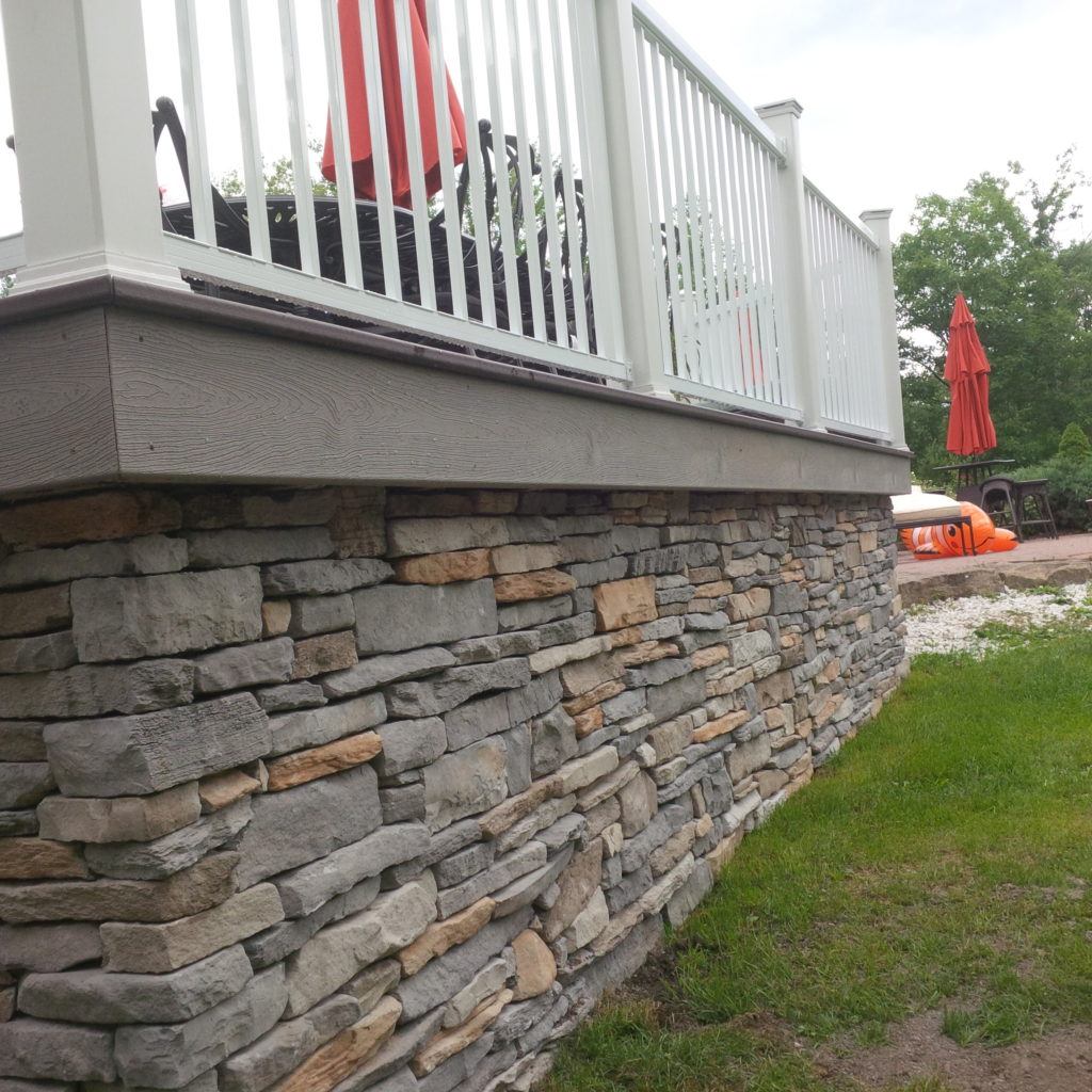 low angle view of custom deck with stone wall foundation
