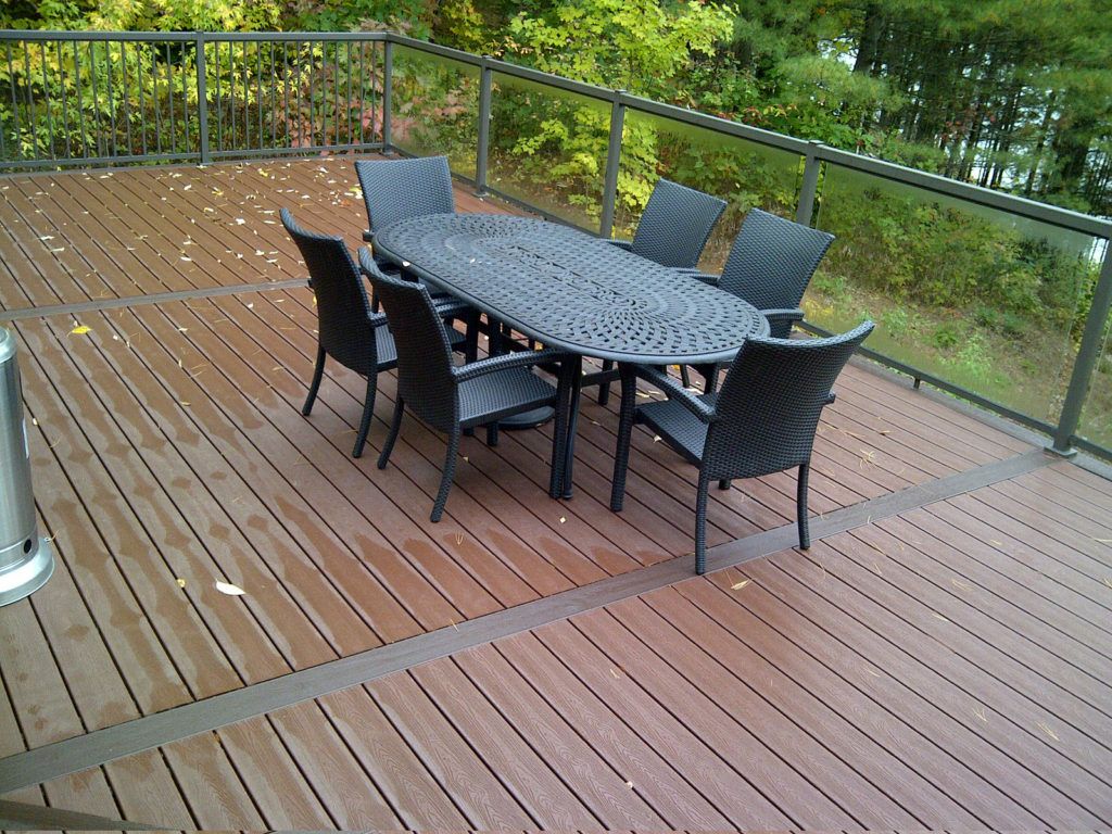 wet custom deck with railings and a patio tableset and chairs in the middle