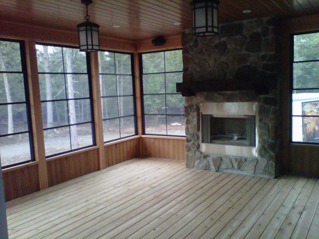 Screened in wooden porch with fireplace