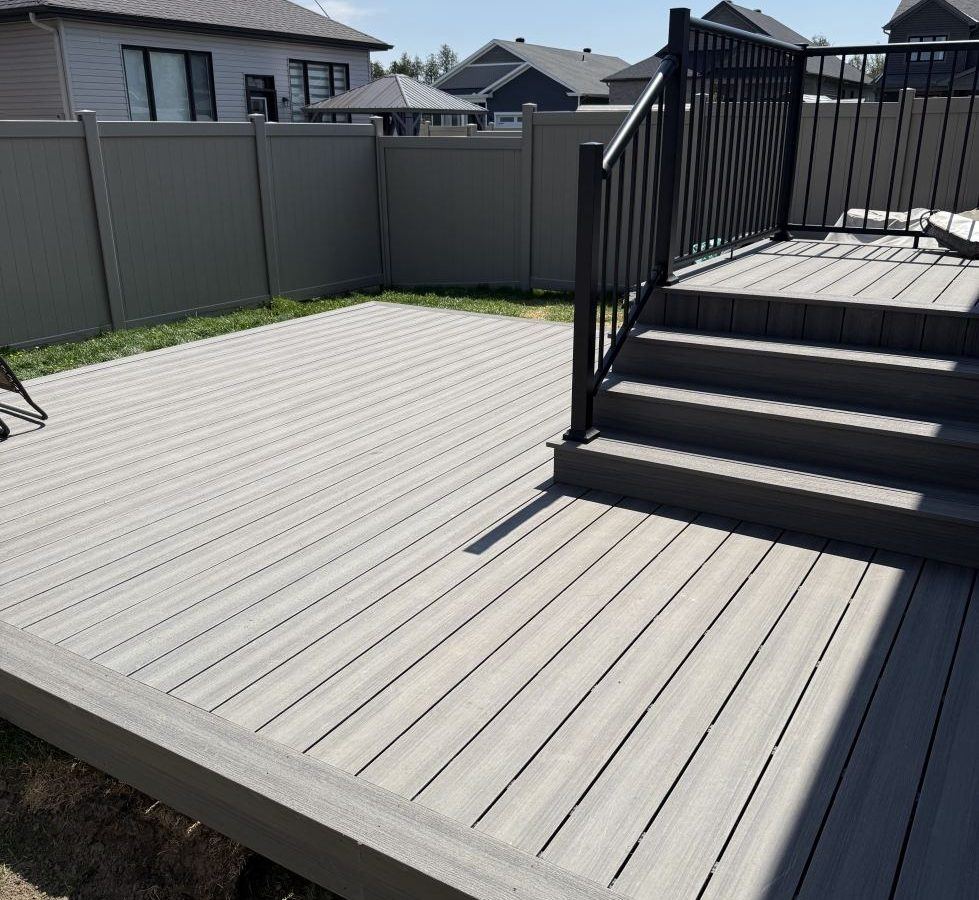 Gray composite deck with steps and black railing.