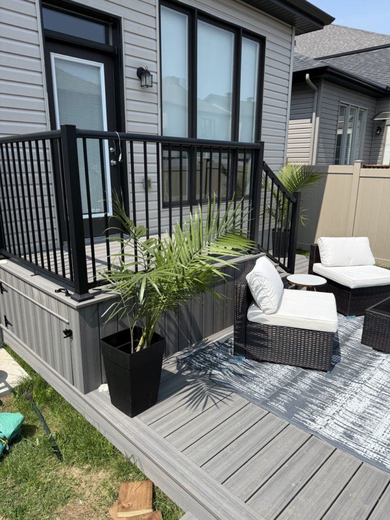 Backyard deck with black railing and outdoor seating.
