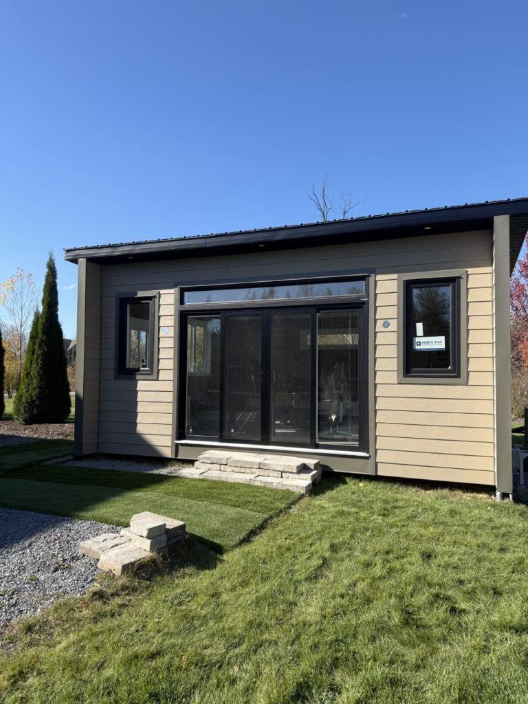 Modern outdoor structure with large glass doors and steps.