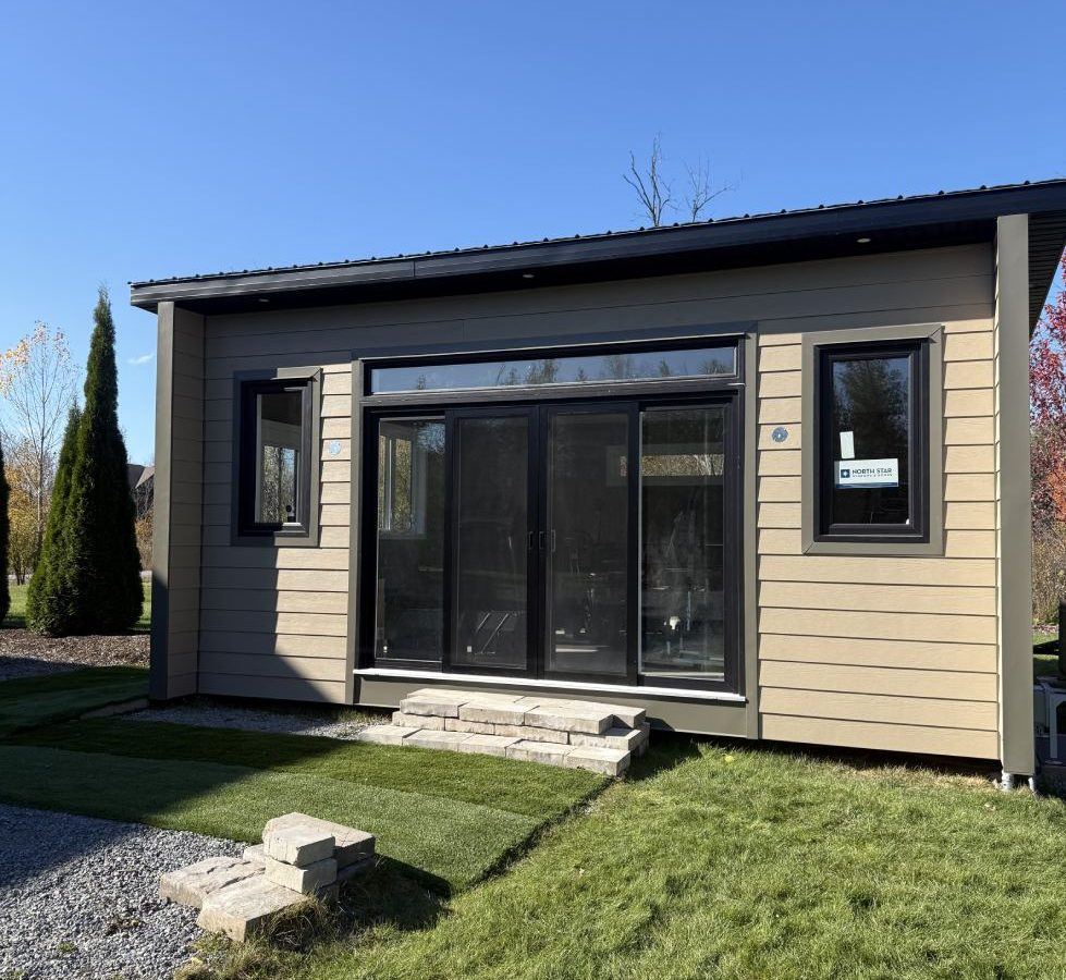 Modern outdoor structure with large glass doors and steps.